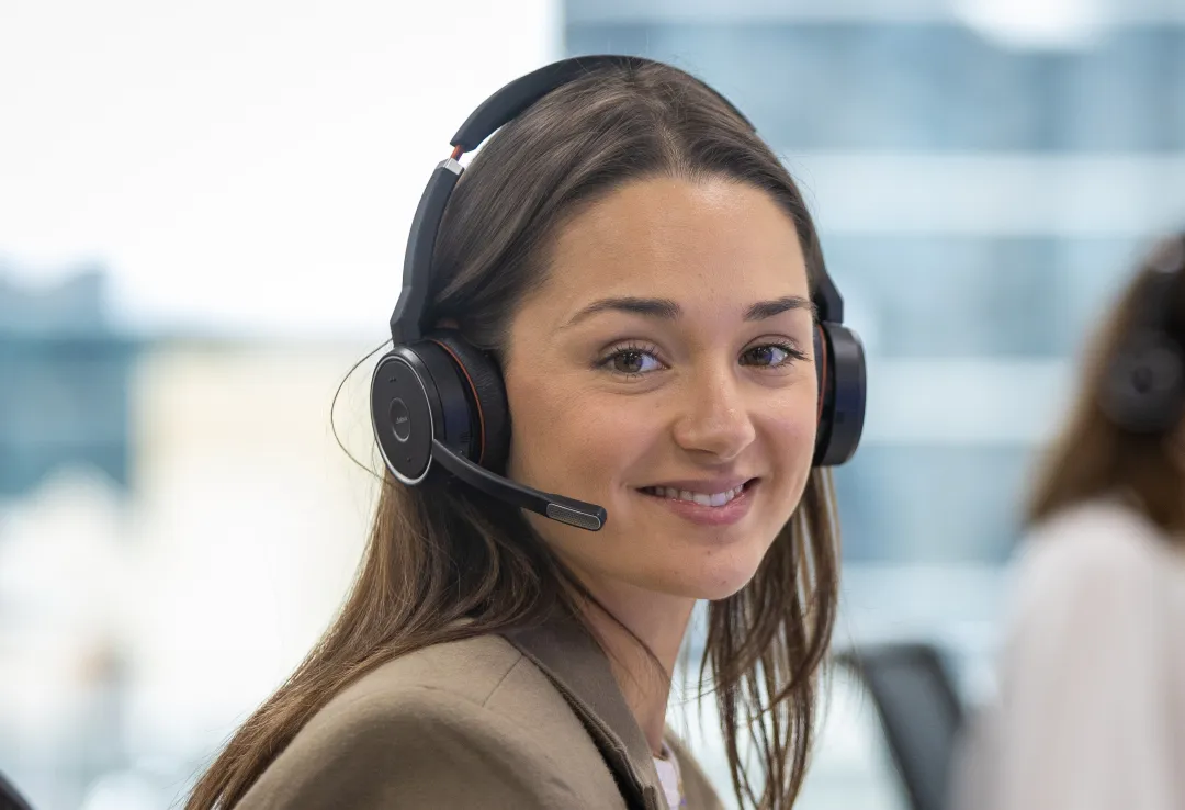 Woman wearing a headset sitting at a desk in an office setting