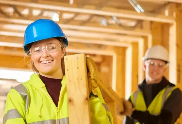 Two people on work site wearing hi vis