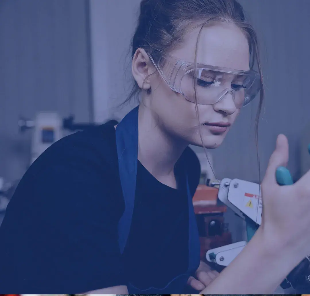 Young woman working with tools wearing protective glasses