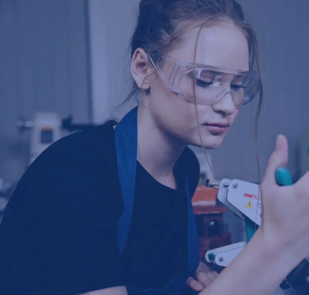 Young woman working with tools wearing protective glasses
