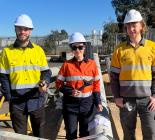 Three tradespeople standing in hi-vis on a depott