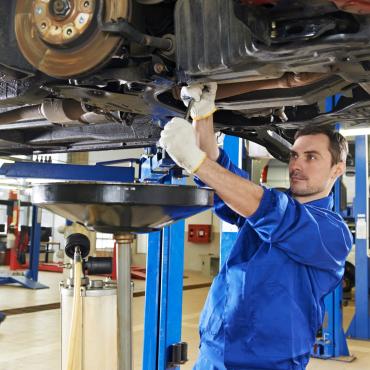 Automotive apprentice repairing a car