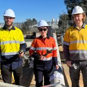 Three tradespeople standing in hi-vis on a depott