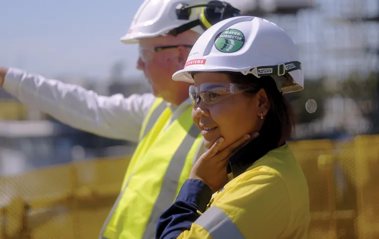 Two people wearing high visibility workwear and hard hats