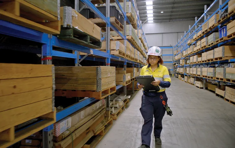 A worker walking through a warehouse checking stock.