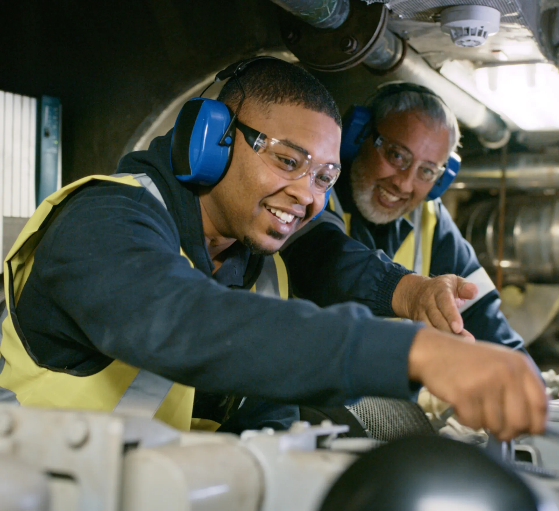 Young apprentice getting instructed by older worker