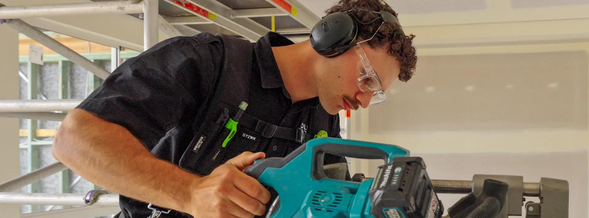 Apprentice Lewis wearing protective eyewear working onsite with tools