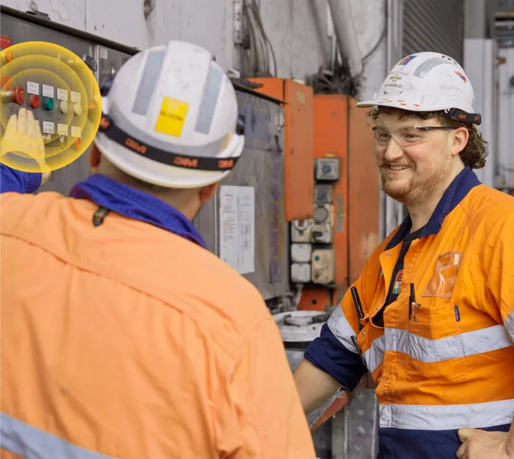 Worker smiling while standing in a warehouse with another worker