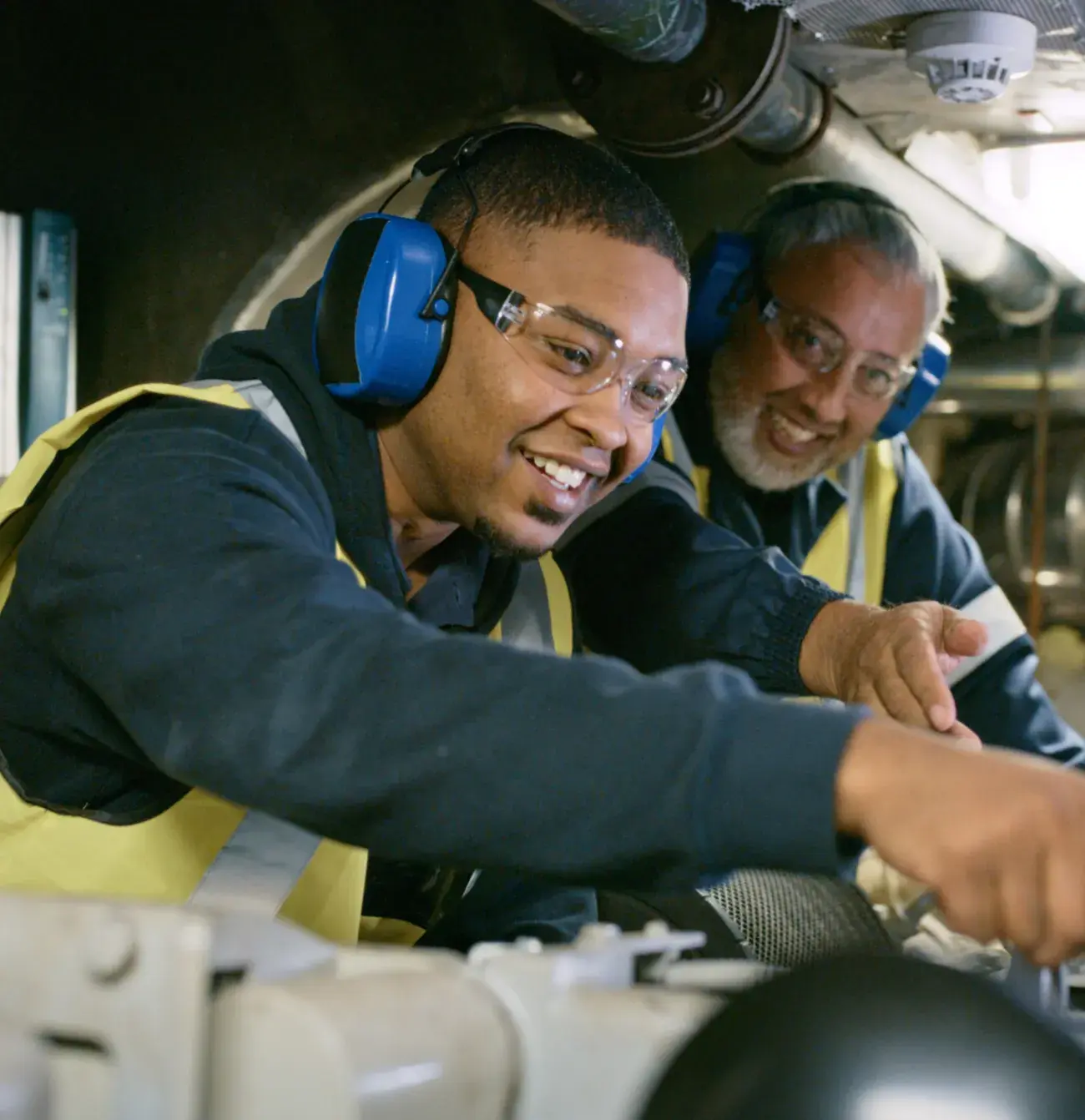 male apprentice and male supervisors in a worksite environment