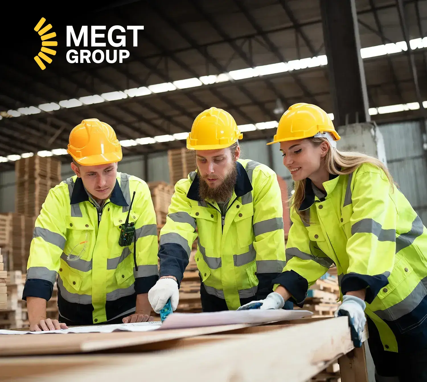 Three blue collar workers standing together at a work bench