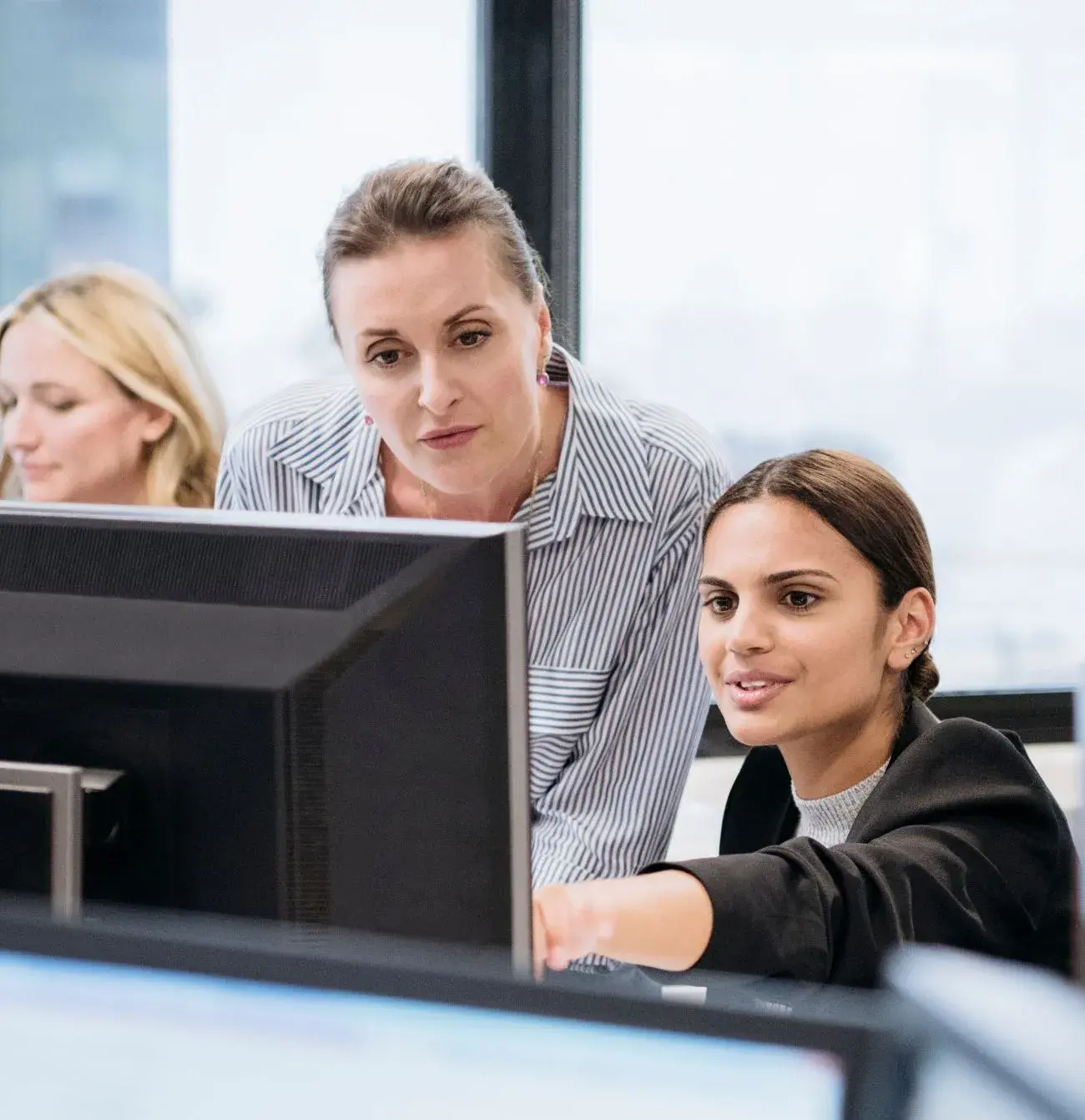 Two people looking at a compute screen in an office environment